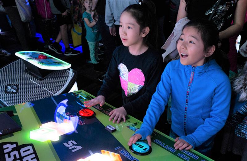 Two children stand at an arcade game at Bowlero in Brooklyn Park, MN