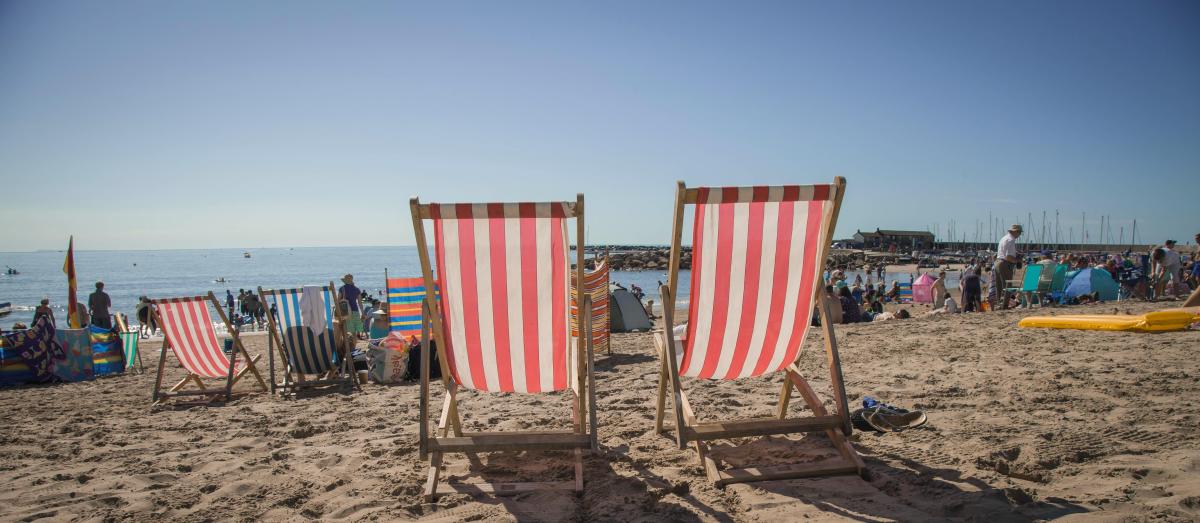 Red and white deck chairs on Lyme Regis Beach