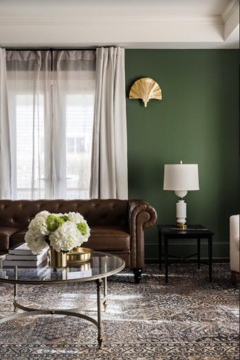 Dark brown leather couch in a living room with a glass table