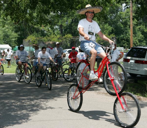 Man Riding 2 Bicycles at Once at Louisiana Bicycle Festival in Abita Springs