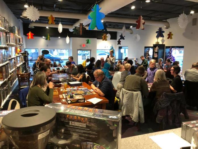 Many people sit at tables playing board games at Empire Board Game Library in Nob Hill