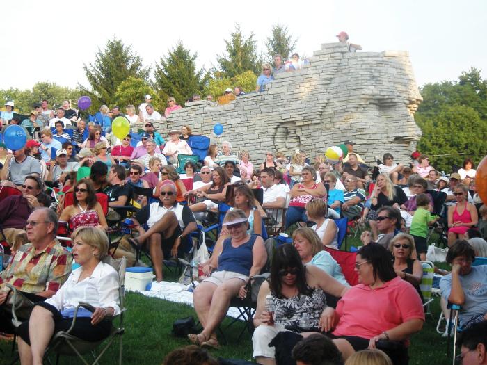 Crowd of people sitting in front of Leatherslips sculpture at Sundays at Scioto concert series.