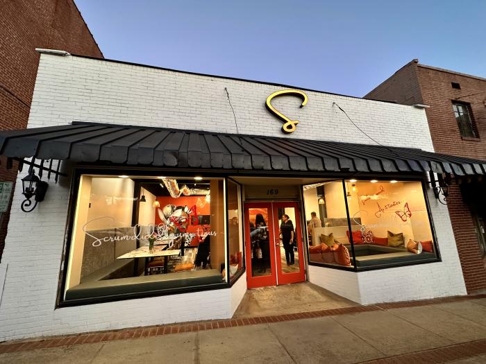 White brick exterior of a restaurant with 2 large windows
