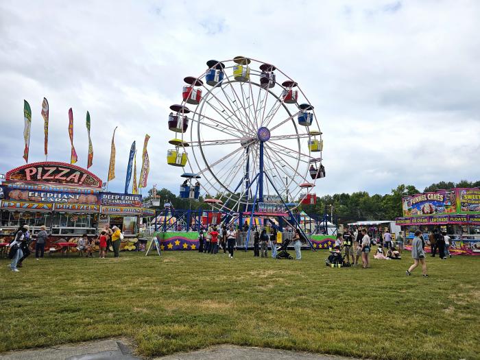 Ferris wheel surrounded by food vendors and festivalgoers at Redstone Arsenal Oktoberfest in Huntsville.