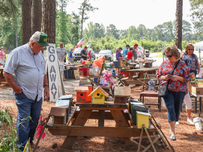 A man and a woman walk through various pieces of woodwork during the 301 Endless Yard Sale.