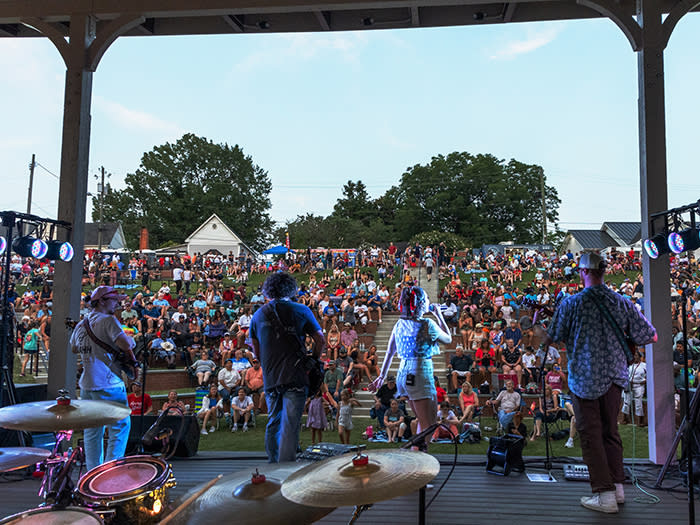 Four individuals wearing Fourth of July festive clothing perform on stage at the Smithfield Amphitheater.