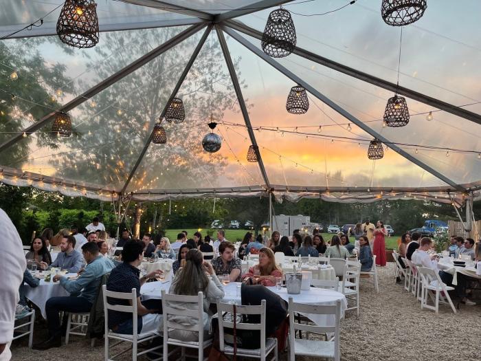 Diners eating outside under a canopy