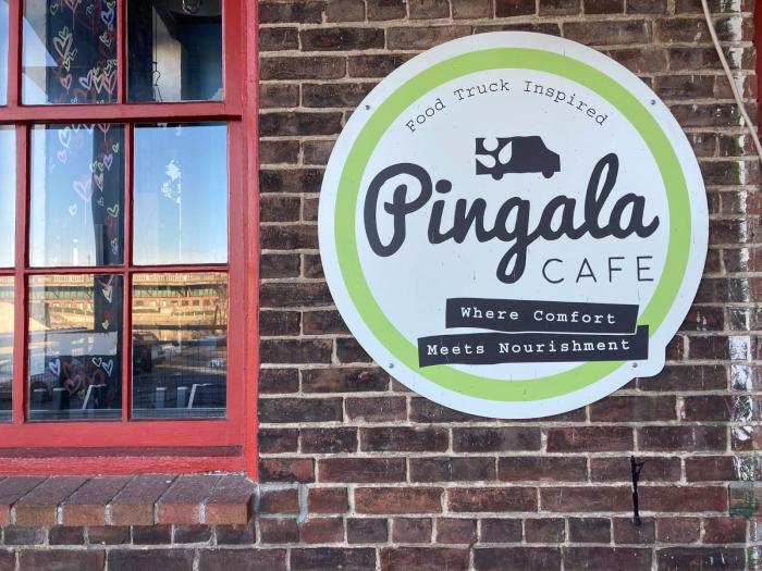 Pingala cafe sign on an exposed brick wall