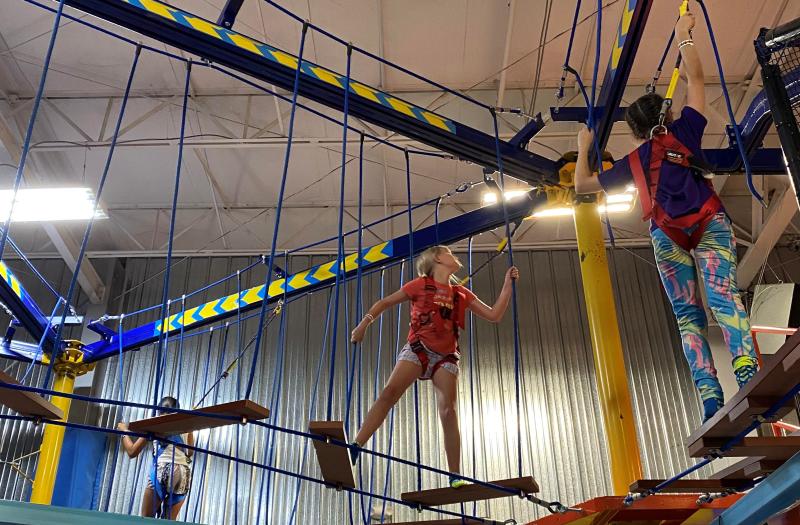 The girls navigating an elevated obstacle course at Urban Air
