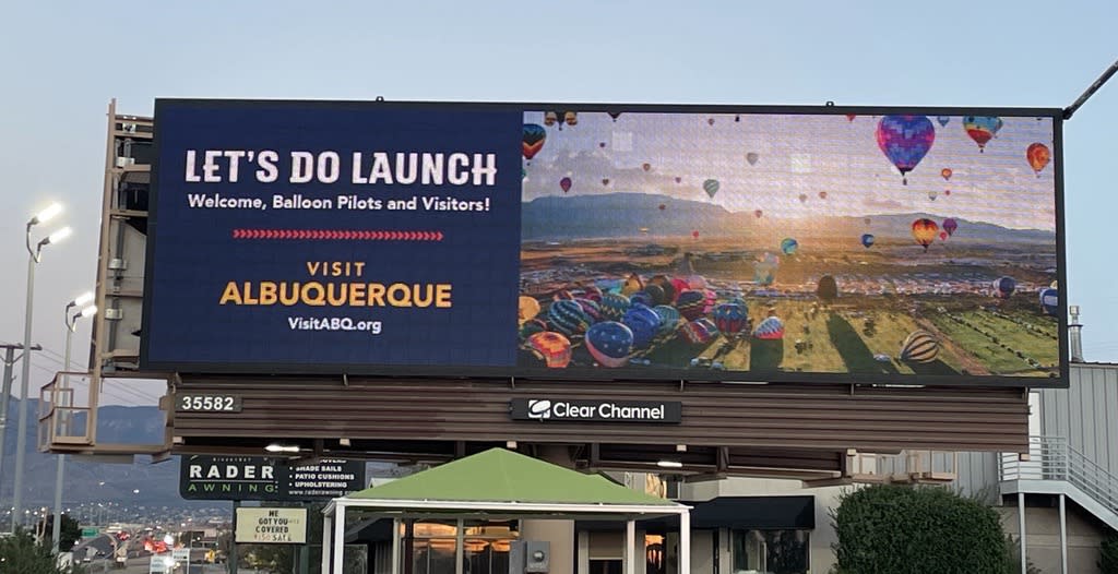 Visit Albuquerque billboard at Jefferson and Paseo reading "let's do launch" welcoming Balloon Fiesta visitors.
