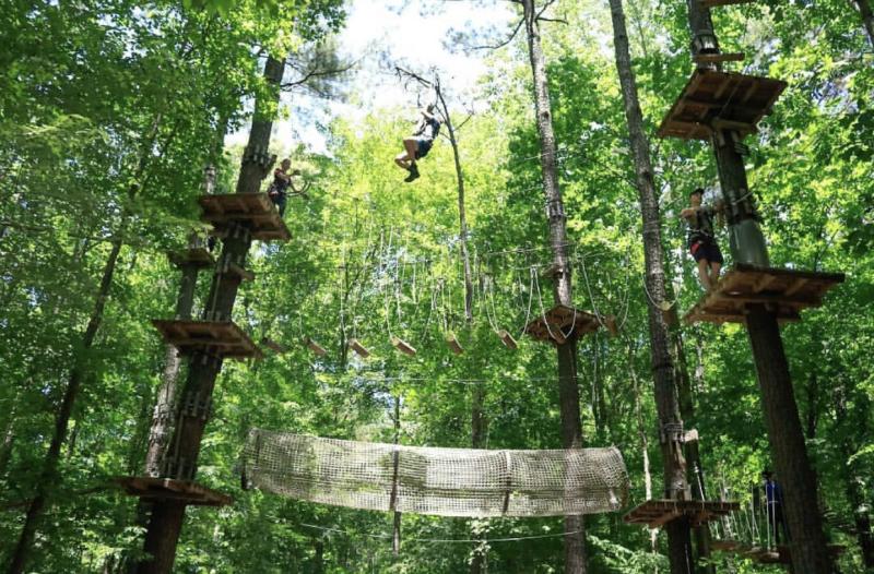 Person zip-lining over trees at the Adventure Park in Virginia Beach