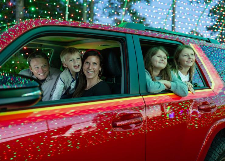A family in a red car enjoys looking out the windows at the Christmas Lights of the Great Christmas Light Show