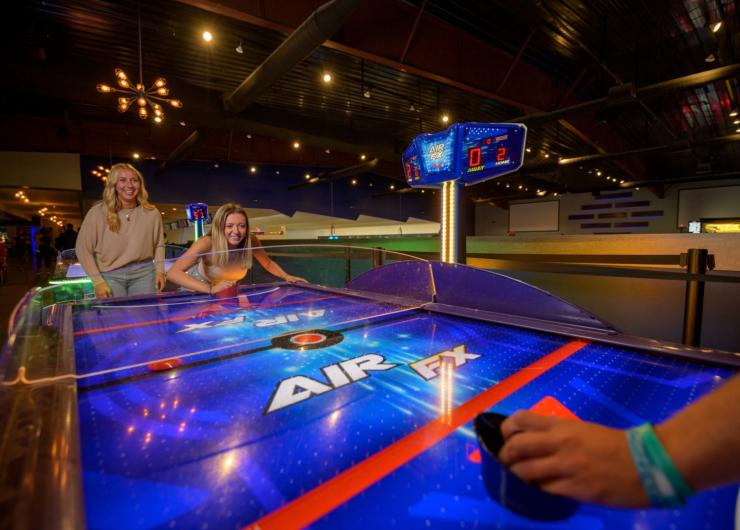 A family playing air hockey at 810 Games
