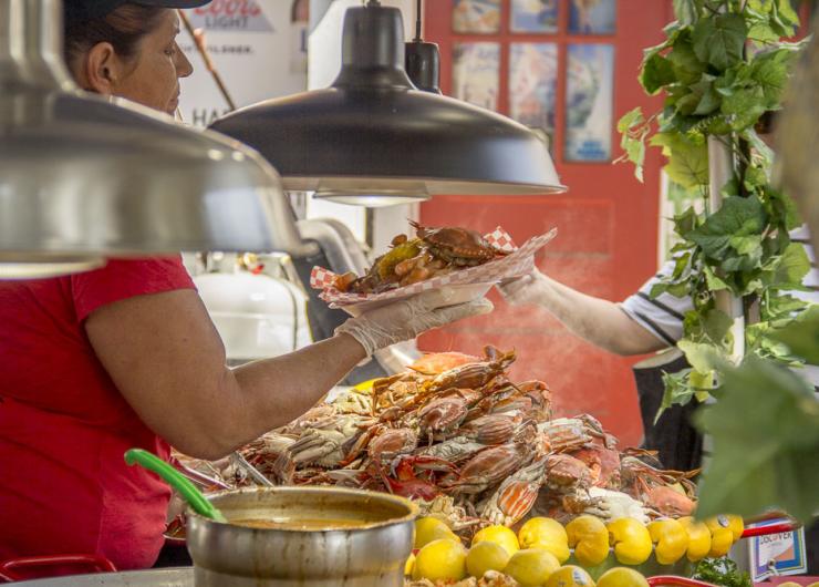 A steaming plate of fresh seafood being served to a customer.