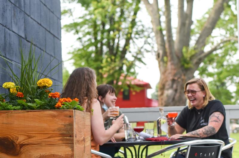 Three women dining on the patio at Cardinal Spirits