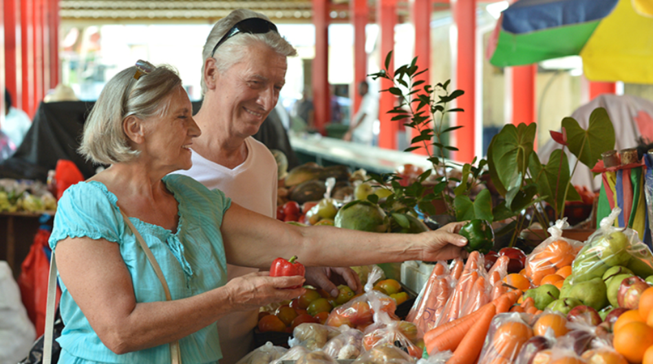 A man and a woman shopping at a farmers market