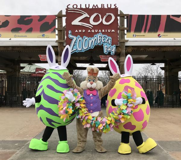 Eggs, Paws and Claws characters - two eggs and the Easter bunny - pose in front of Columbus Zoo entrance