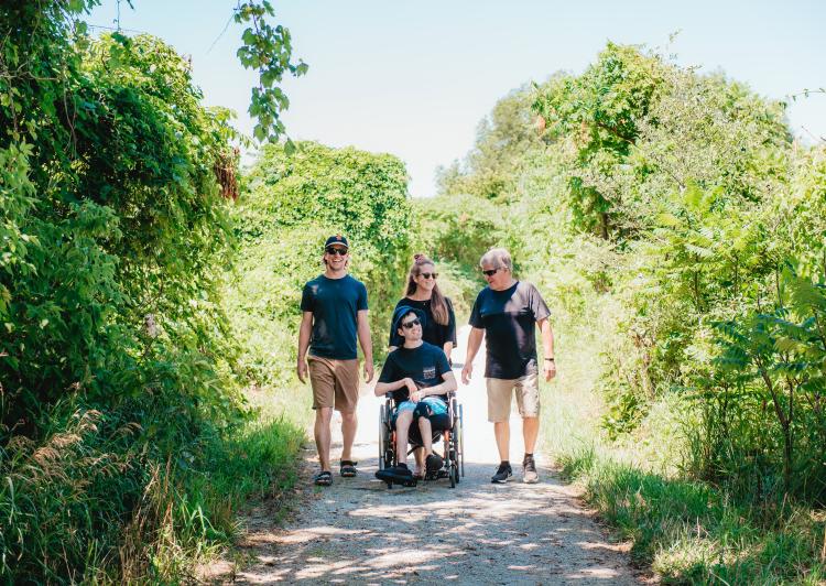 Family with someone in wheelchair walking on a trail