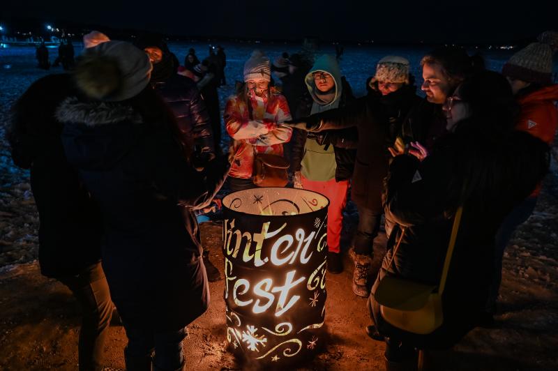 Group around a bonfire on the beach during Winterfest