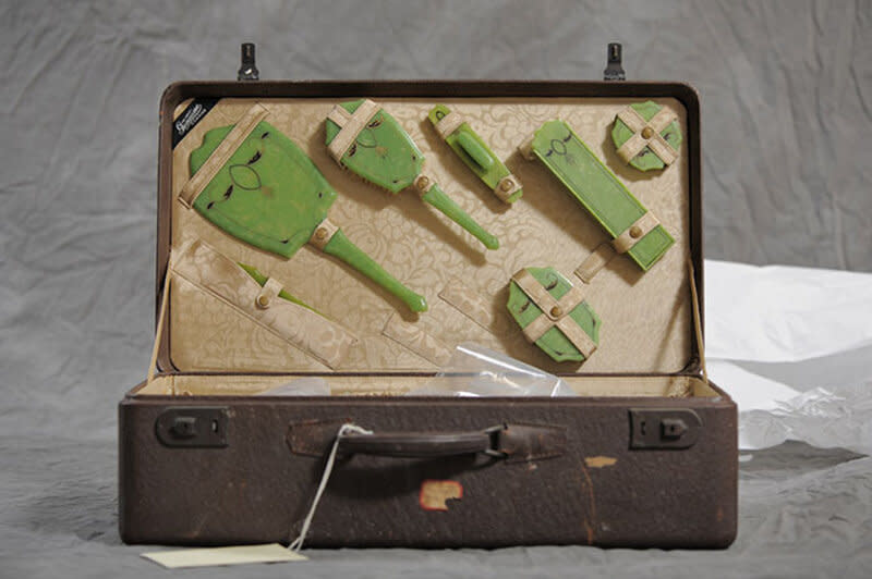 Old brown suitcase with a green hygiene set from the early 1900s