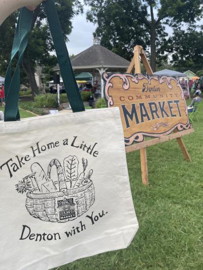A canvas bag reading "Take Home a Little Denton with You" at Denton Community Market