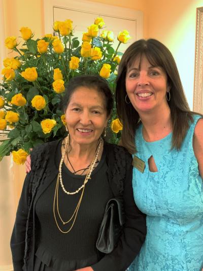 Carmen Vargas with Lynell Seabold in front of yellow roses