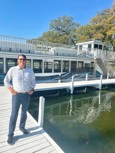 Dave Sekeres of Lake Lawn Resort standing on the pier in front of the Lake Lawn Queen.