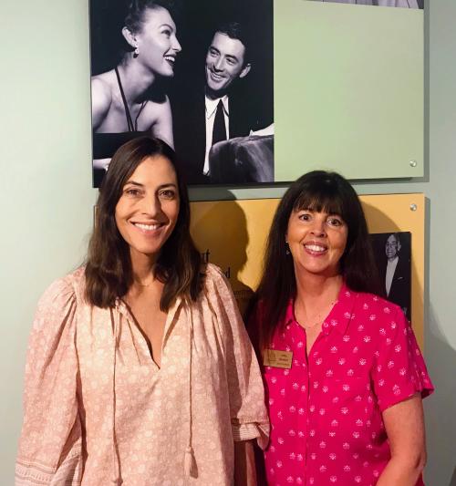 Cecilia Peck standing next to Lynell Seabold at the Ava Gardner Museum in front of a photo of Ava Gardner and Gregory Peck