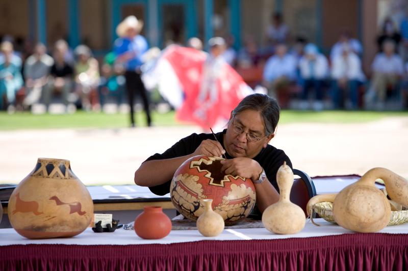 Native American artist paints pottery at the Indian Pueblo Cultural Center