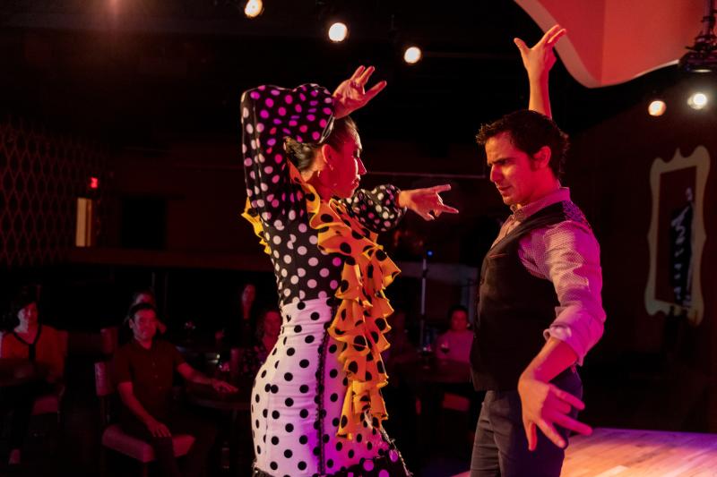 Two flamenco dancers perform while an audience watches