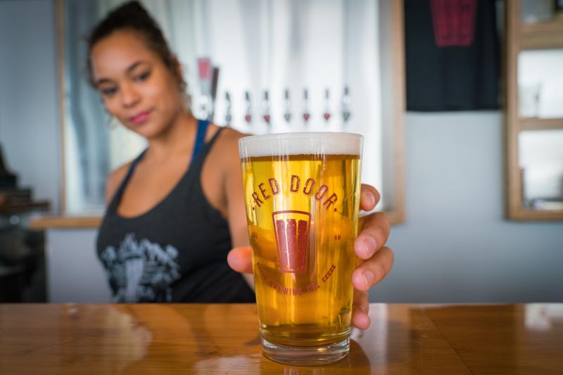 Bar tender serving beer at Red Door Brewery
