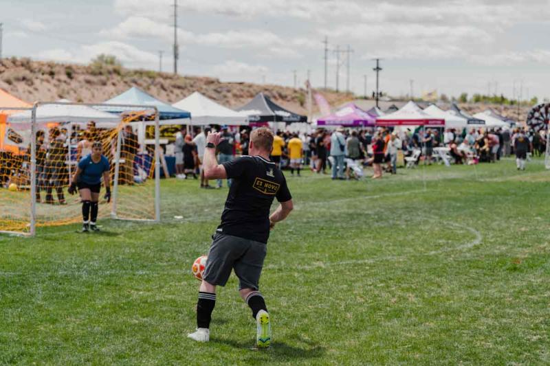 A soccer player runs towards the goal at the Brewers & Distillers Cup