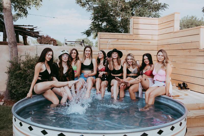 A group of young women sit around a pool