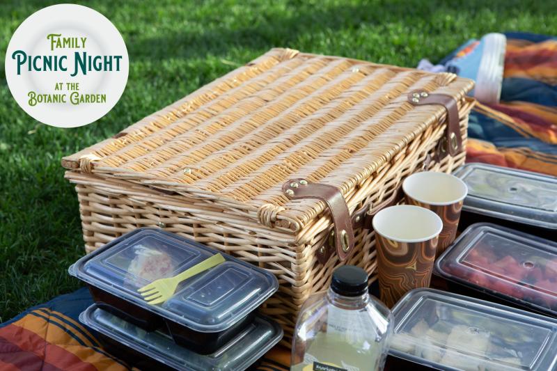 A picnic basket and containers of food with the logo for Family Picnic Night at the Botanic Garden