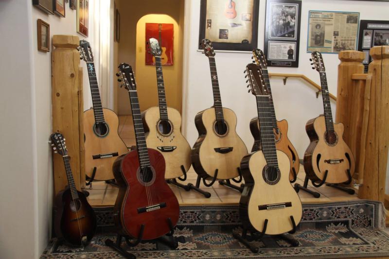 Eight guitars created by Pimentel Guitars sit on display.