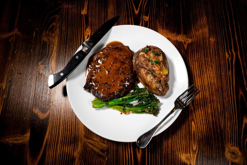 A steak, baked potato and broccolini from Vernon's Speakeasy