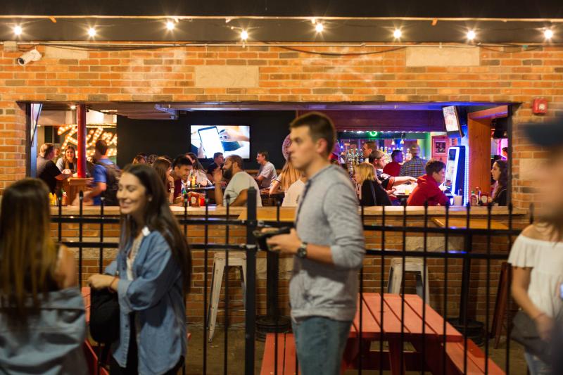 People talking outside of a jam-packed Kilroy's at night