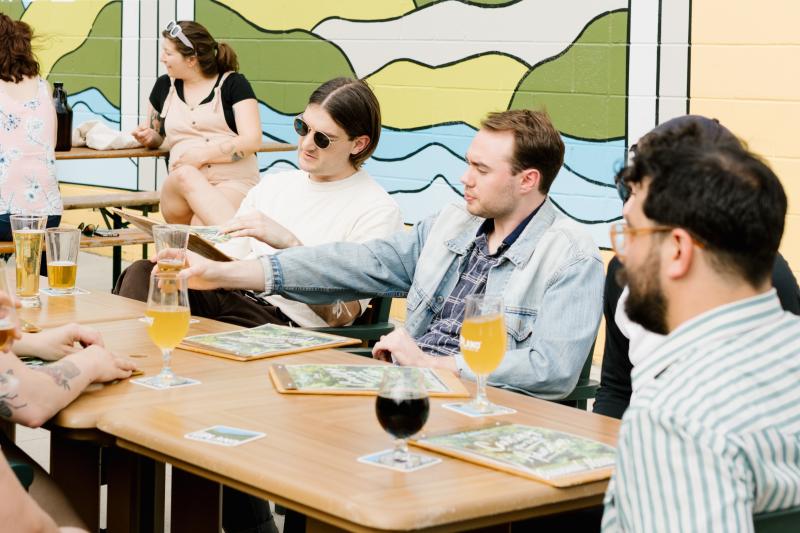 Several men sitting at a table on the patio at Upland Brewing Co.