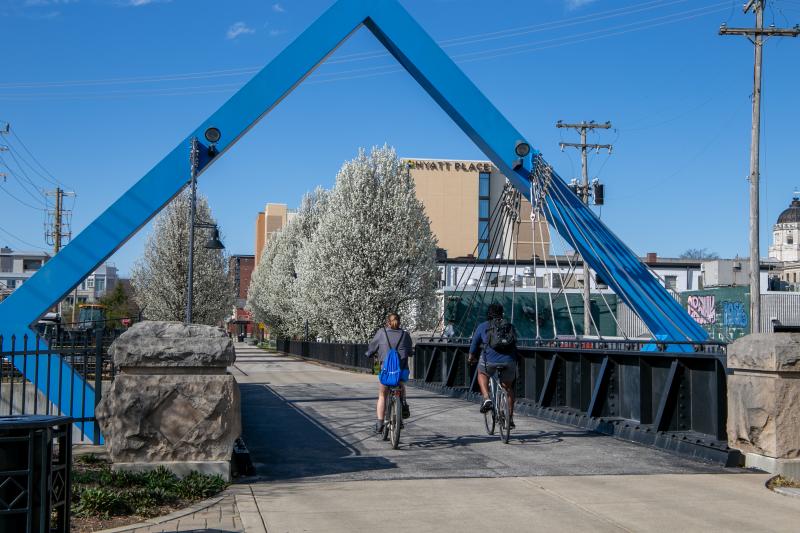 A man and woman riding bikes on the B-Line Trail during spring
