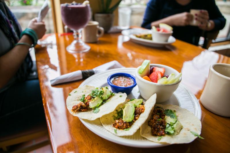 Two women sitting at a table with breakfast plates at Bedrak Cafe