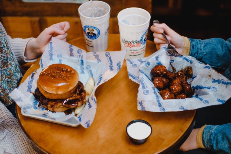 Visitors enjoy a burger and wings from Bloomington's famous BuffaLouie's restaurant.