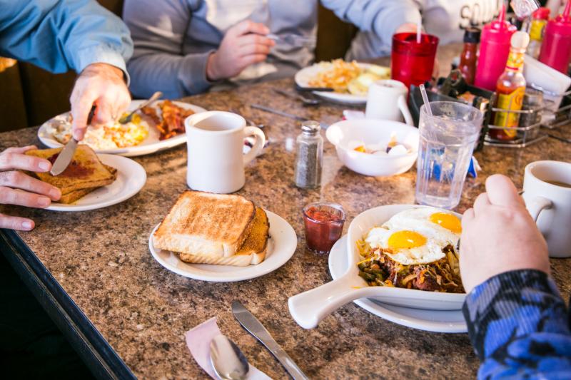 An assortment of breakfast dishes at a table full of people at Cozy Table