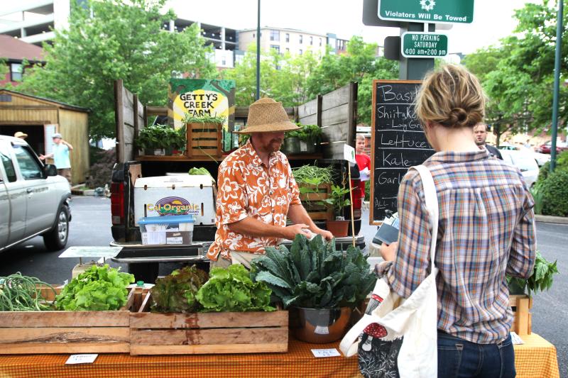 Woman purchasing produce from the Gettys Creek Farm vendor at the Bloomington Community Farmers' Market