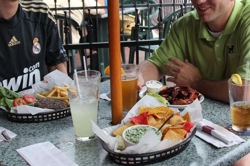 Two men sitting at a table full of food on the patio at Crazy Horse