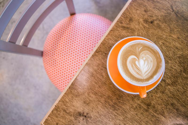 A latte on a table at Needmore Coffee Roasters