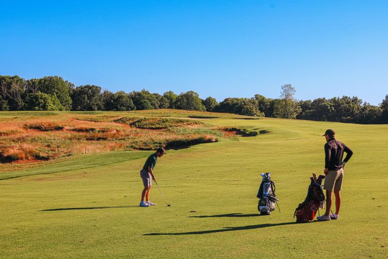 Two men playing golf at the Pfau Course