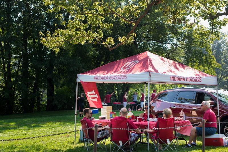 People tailgating under a canopy