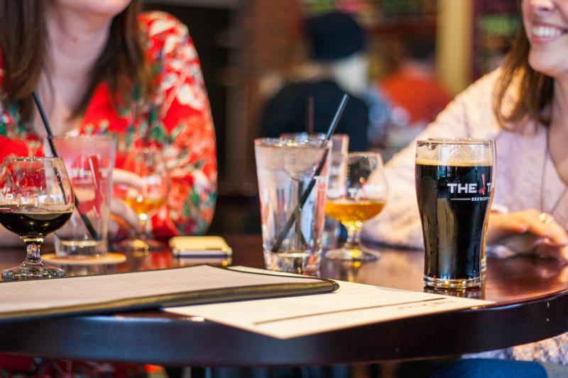 Two women sitting at a table full of drinks at The Tap