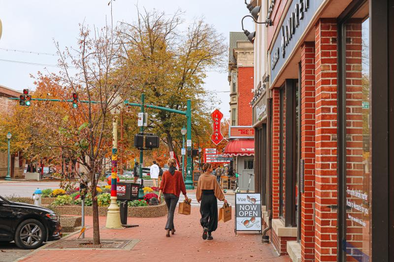 Two women walking with shopping bags toward the Buskirk-Chumley Theater