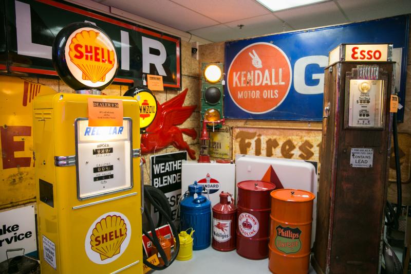 A booth full of vintage car signs and fuel pumps